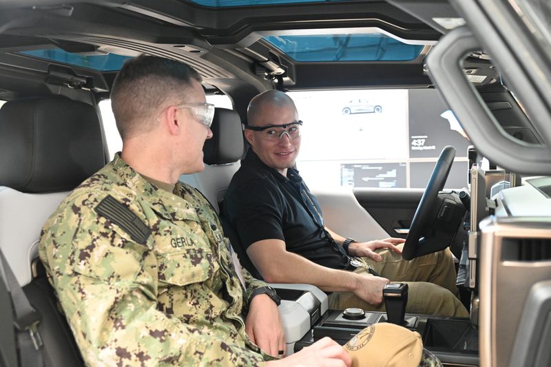 A Navy electronics technician in a SkillBridge internship shows his executive officer the National Renewable Energy Laboratory technology he works with.